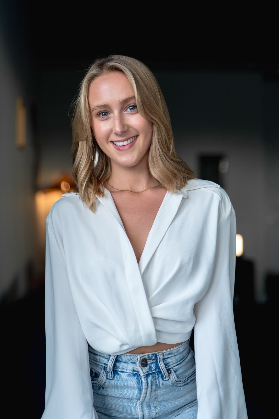 Ellie Lillian smiling in a white blouse